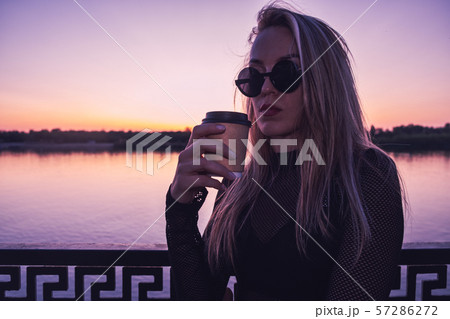 Woman With Takeaway Coffee Cup Standing By The Sunset Lake Woman With Takeaway Coffee Cup Standing By The Sunset Lake 57286272