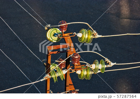 High voltage power-tower of rusty metal detail with set of glass electrical insulators 57287564