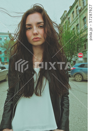 Peaceful looking girl posing with windy hair ouside, wide angle smartphone lens imitation vertical 57287627