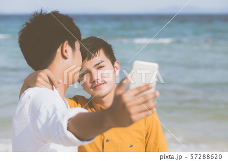 Gay portrait young couple smiling taking a selfie photo together with smart mobile phone Gay portrait young couple smiling taking a selfie photo together with smart mobile phone 57288620