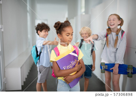 Dark-skinned girl suffering from bullying at school Dark-skinned girl suffering from bullying at school 57306898