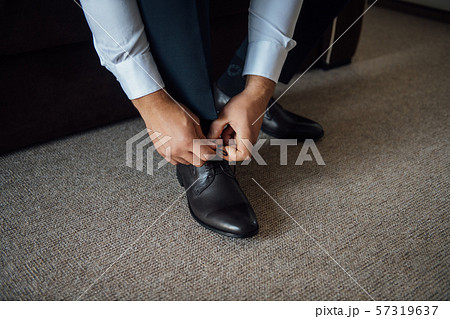 Business man tying shoe laces on the floor. Close-up 57319637