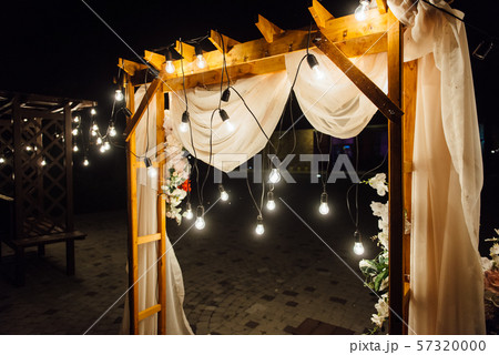 night wedding ceremony. A garland of light bulbs. candles in glass flasks in the evening. 57320000