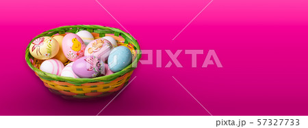 Wicker basket with Easter eggs hand painted on color tabletop background 57327733