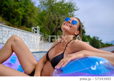 Summer image of stunning suntanned girl sitting on 57343985