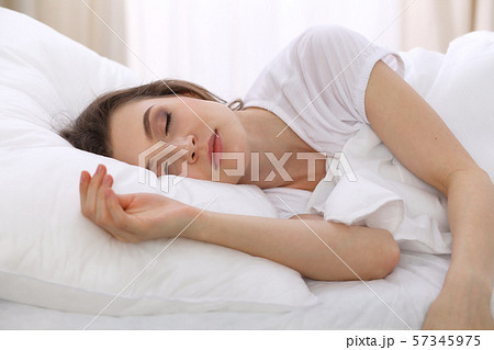 Beautiful young woman sleeping while lying in her bed. Concept of pleasant and rest reinstatement Beautiful young woman sleeping while lying in her bed. Concept of pleasant and rest reinstatement 57345975