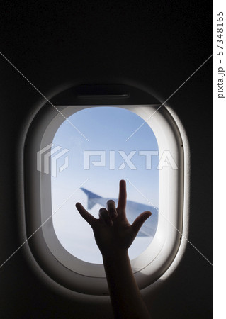 Silhouette of girl's hand gesturing by airplane window 57348165