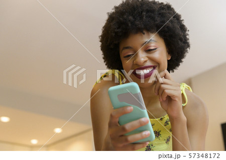 Smiling young woman using smart phone 57348172