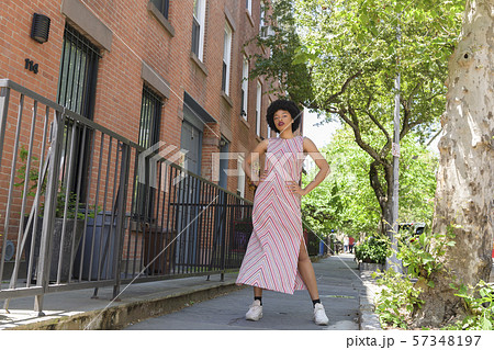 Woman wearing striped dress by brick townhouses Woman wearing striped dress by brick townhouses 57348197