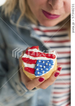 Woman holding American flag cupcake 57348231