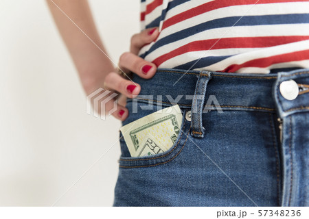 Woman with money in her jeans pocket Woman with money in her jeans pocket 57348236