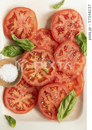Sliced tomatoes with basil and salt Sliced tomatoes with basil and salt 57348237