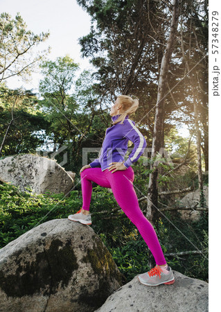 Woman wearing sportswear on rocks in forest Woman wearing sportswear on rocks in forest 57348279