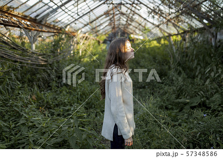 Young woman in abandoned greenhouse 57348586