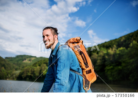 Young tourist man traveller with backpack standing in nature, resting. Young tourist man traveller with backpack standing in nature, resting. 57350166