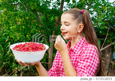teen girl holding a bowl of raspberries in the teen girl holding a bowl of raspberries in the 57351655