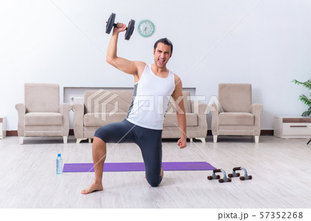 Young man training and exercising at home Young man training and exercising at home 57352268