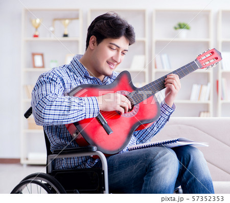 Disabled man playing guitar at home 57352353