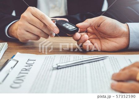 Sale agent giving Car key to customer and sign 57352590