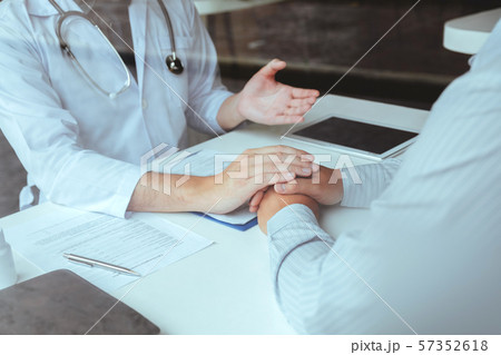 Doctor holding hands for comforting and care Doctor holding hands for comforting and care 57352618