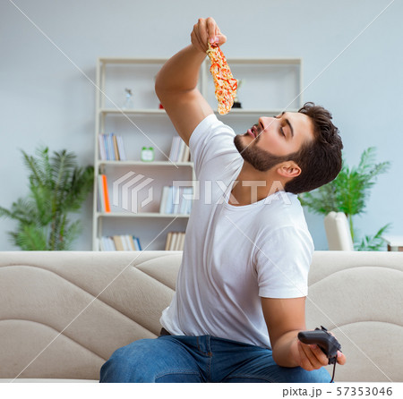 Man eating pizza having a takeaway at home relaxing resting 57353046