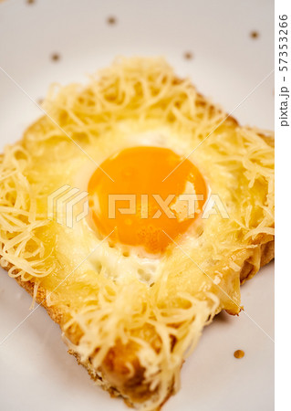 Delicious toast with fried egg on wooden kitchen table 57353266