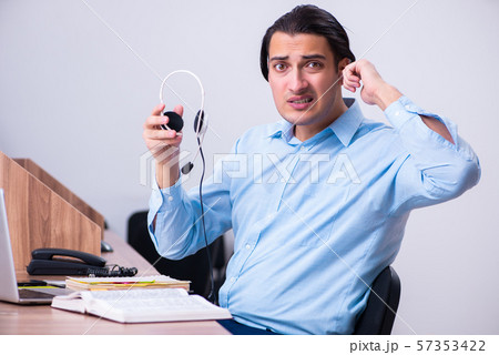 Call center operator working at his desk Call center operator working at his desk 57353422