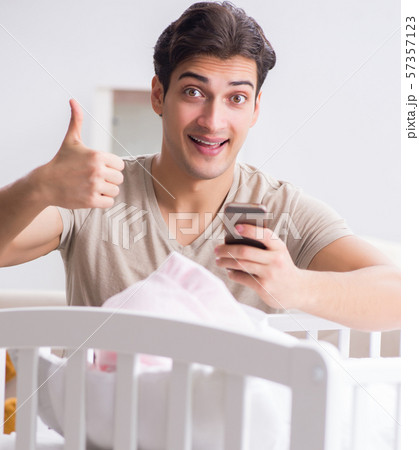 Young father enjoying time with newborn baby at home 57357123