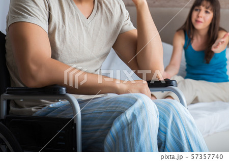 Desperate man on wheelchair with his sad wife Desperate man on wheelchair with his sad wife 57357740