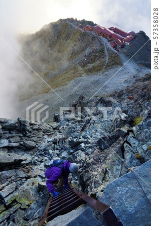 槍ヶ岳山頂の梯子を下りる登山者 57358028
