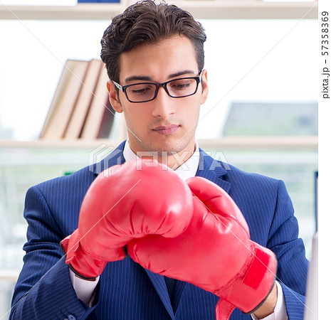 Businessman with boxing gloves angry in office Businessman with boxing gloves angry in office 57358369