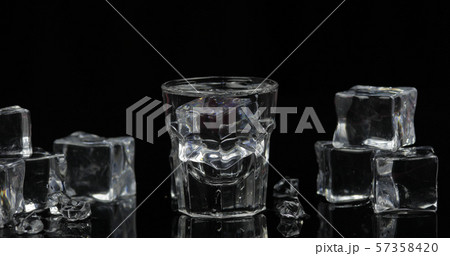 Shot of vodka with ice cubes against black background 57358420