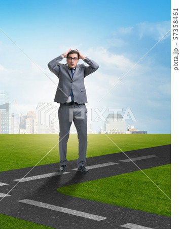 Young businessman at crossroads in uncertainty concept Young businessman at crossroads in uncertainty concept 57358461