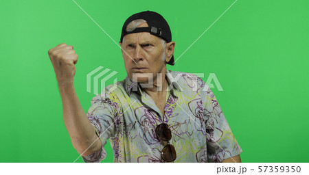 Senior man tourist quarrels at someone threateningly moves with his hands fist 57359350
