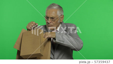 Elderly businessman with shopping bags. Old man in formal wear after shopping Elderly businessman with shopping bags. Old man in formal wear after shopping 57359437