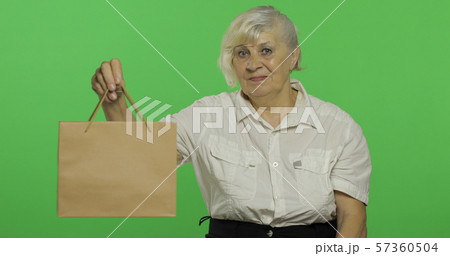 An elderly woman with shopping bag. Shopping. Presents. Chroma key An elderly woman with shopping bag. Shopping. Presents. Chroma key 57360504