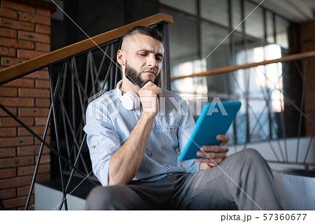 Businessman reading e-mail and feeling thoughtful Businessman reading e-mail and feeling thoughtful 57360677