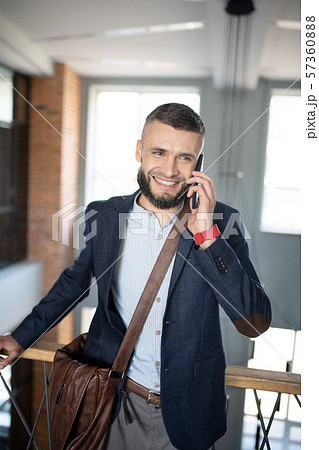 Smiling businessman speaking with colleague by the phone 57360888