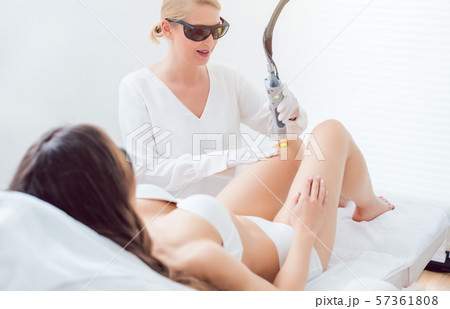 Woman in leg hair removal session at beauty parlor 57361808