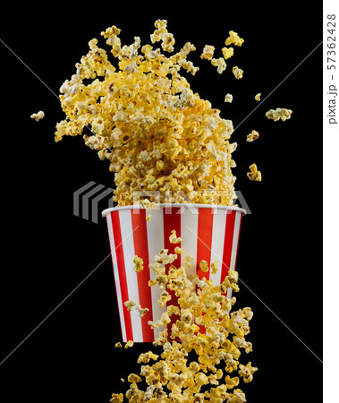 Flying popcorn from striped bucket isolated on black background Flying popcorn from striped bucket isolated on black background 57362428