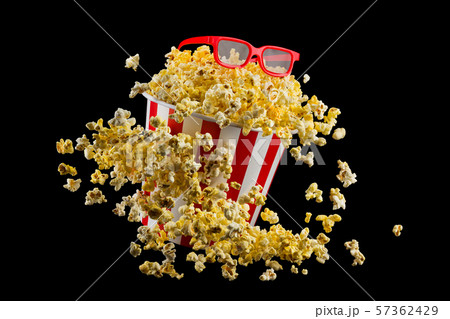 Flying popcorn from striped bucket isolated on black background Flying popcorn from striped bucket isolated on black background 57362429