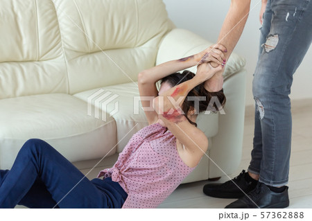 domestic violence, victim and abuse concept - cruel aggressive man grabbing woman lying on the floor 57362888