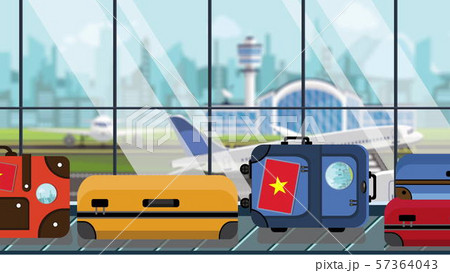 Suitcases with Vietnamese flag stickers on baggage carousel in airport, close-up. Tourism in Vietnam 57364043