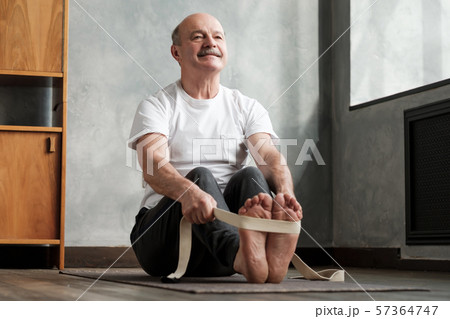 Senior hispanic man sitting in paschimottanasana or Intense Dorsal Stretch pose 57364747