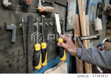 Caucasian man hand taking a chisel for wood working. Caucasian man hand taking a chisel for wood working. 57364812