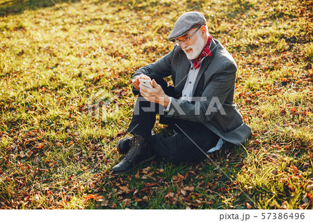 Elegant old man in a sunny autumn park 57386496