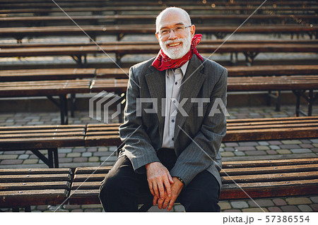 Elegant old man in a sunny autumn park 57386554