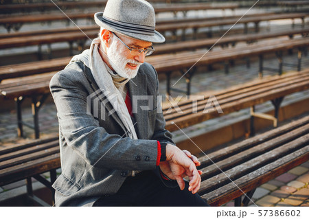 Elegant old man in a sunny autumn park Elegant old man in a sunny autumn park 57386602