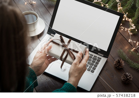 Christmas sales. Woman with gift, typing by laptop Christmas sales. Woman with gift, typing by laptop 57438218