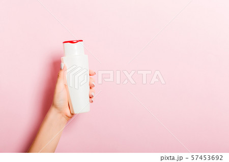 Female hand holding cream bottle of lotion 57453692